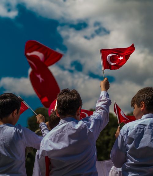Free Children outdoor waving Turkish flags in İzmir, Türkiye under a bright sky. Stock Photo