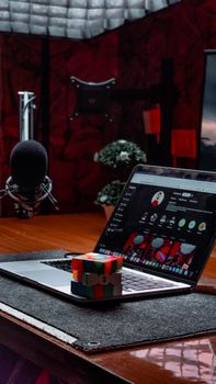 Modern office scene with a laptop, Rubik's Cube, and microphone on a desk. Ideal for creative workspace themes.