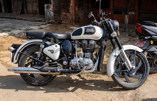 Free Vintage Royal Enfield motorcycle parked in a sunny street of Kathmandu, Nepal. Stock Photo