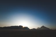 Breathtaking sunrise illuminating the iconic rock formations of Wadi Rum desert in Jordan.