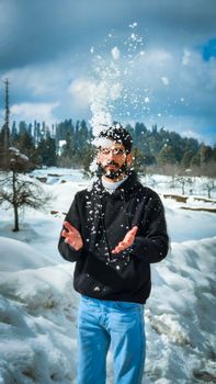 Portrait of a man enjoying snow in a scenic winter landscape in Kashmir.