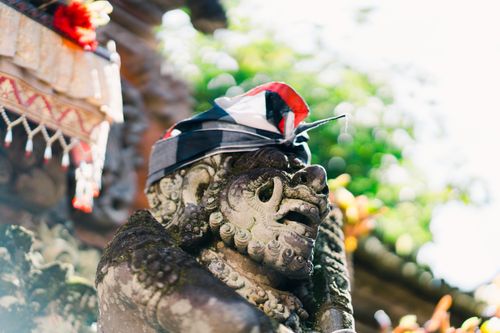 Free Detailed stone sculpture with headscarf at a Balinese temple, captured in sunlight. Stock Photo