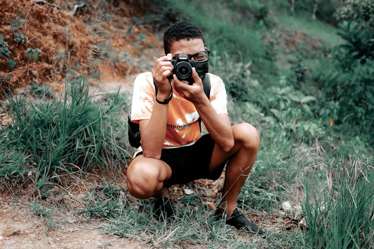 Crouching Man Taking A Photo