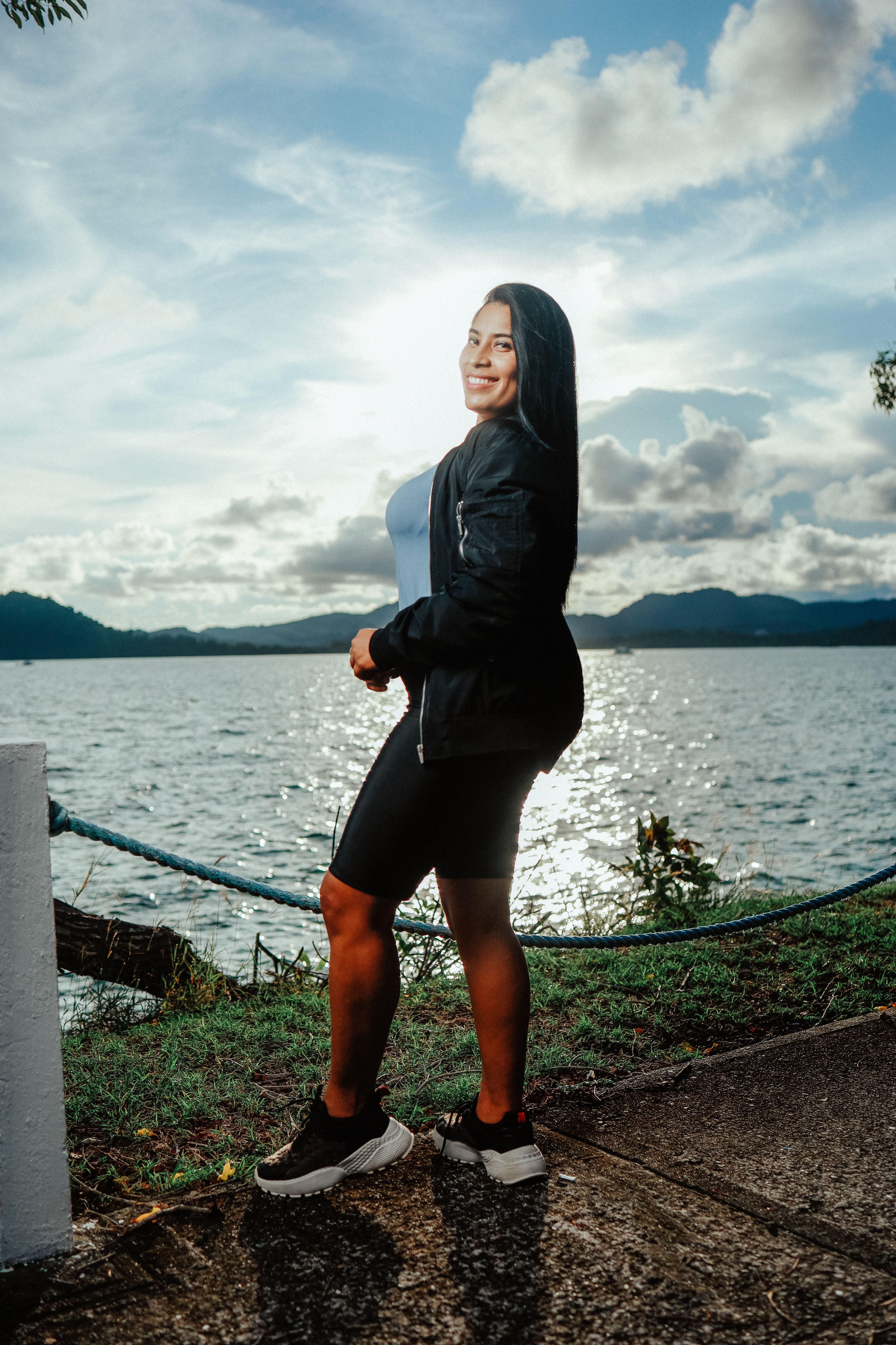 Smiling Brunette Woman Posing by Lake · Free Stock Photo
