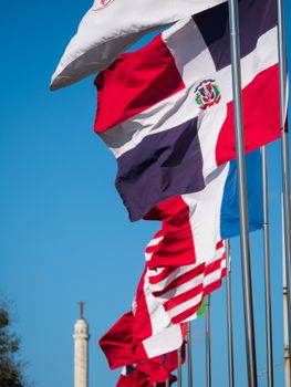 Flags of the Dominican Republic waving in Santiago De Los Caballeros, clear blue sky backdrop.