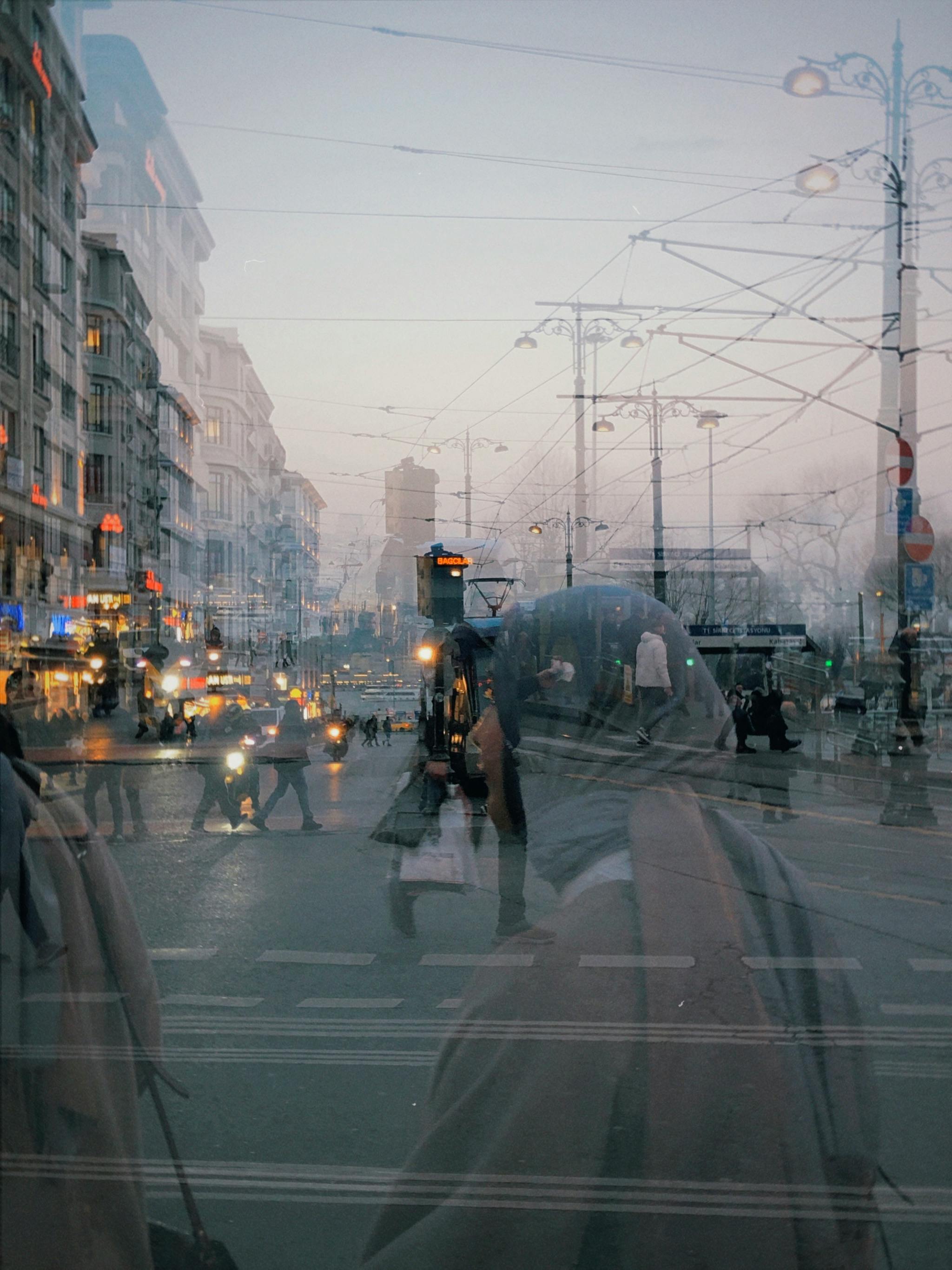 Mystical city scene with silhouettes and reflections at dusk, capturing hustle and bustle.