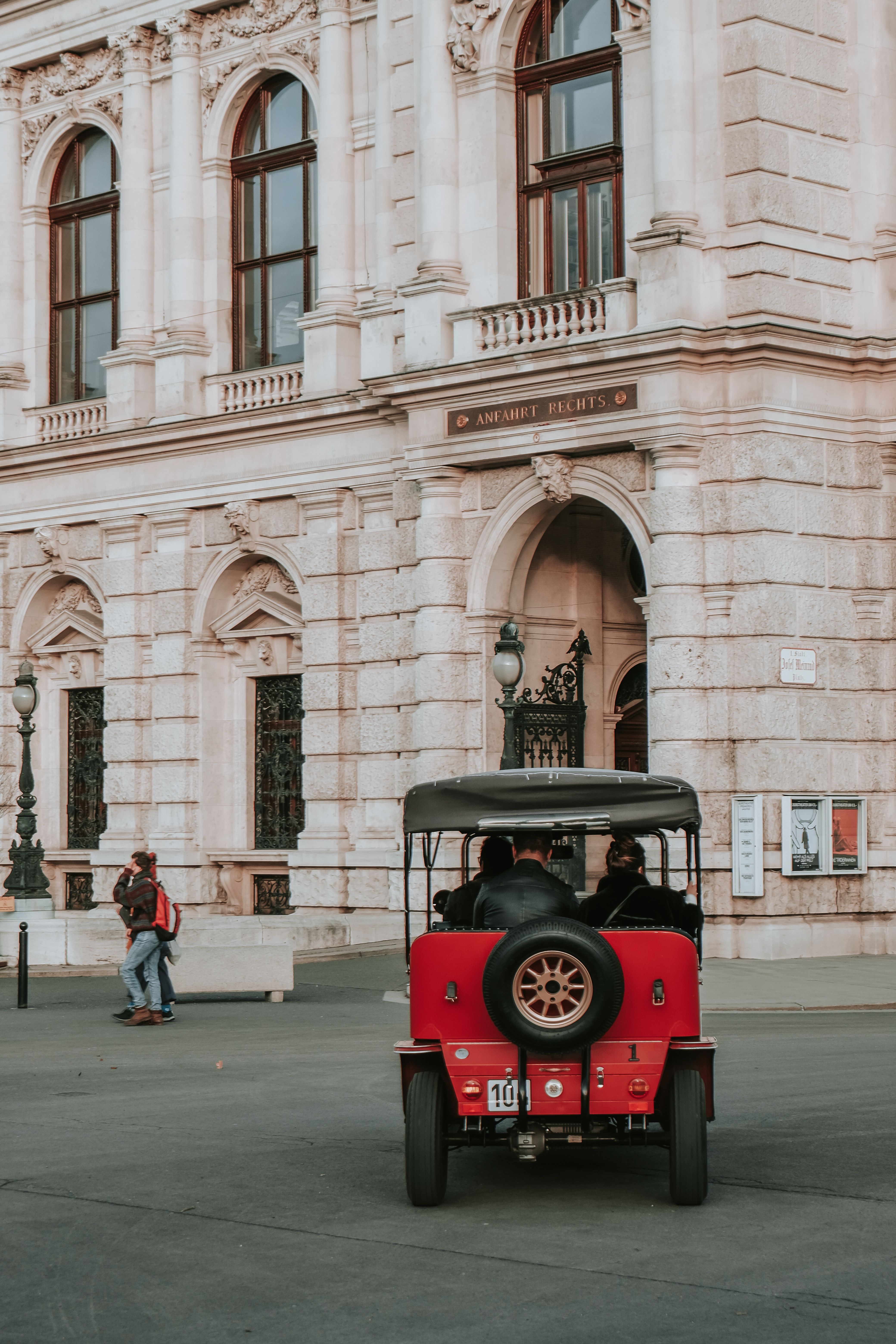 A red car is parked in front of a building · Free Stock Photo