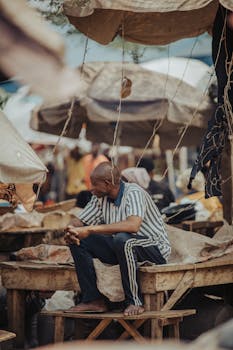 A man sitting in a bustling Indian market reflecting small business life.