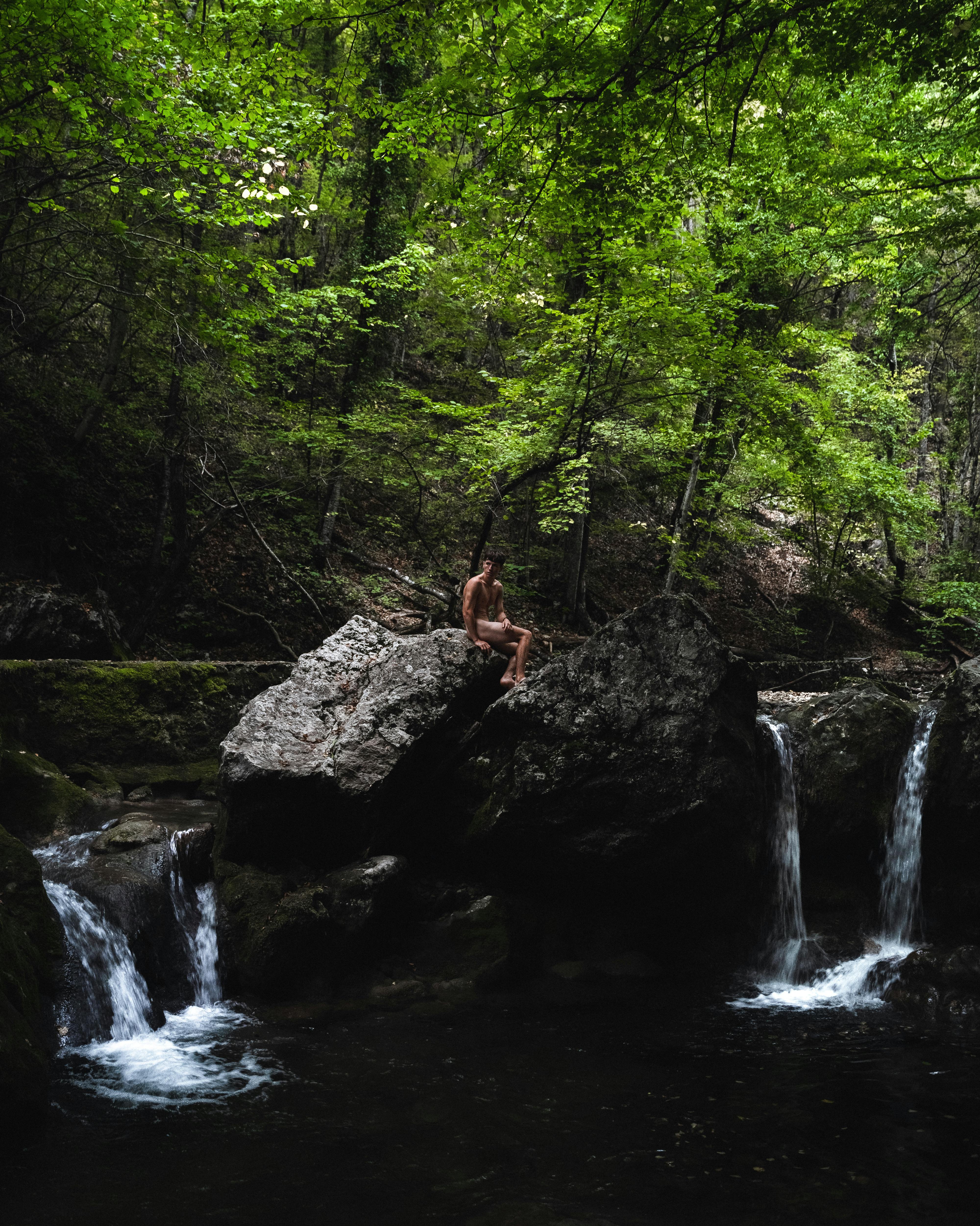 Naked Man Sitting over a Forest Waterfall · Free Stock Photo