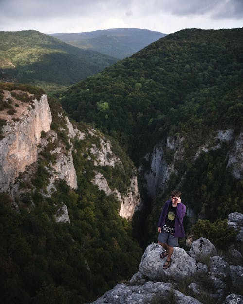 High Angle Shot of a Young Man Standing on the Edge of a Cliff 