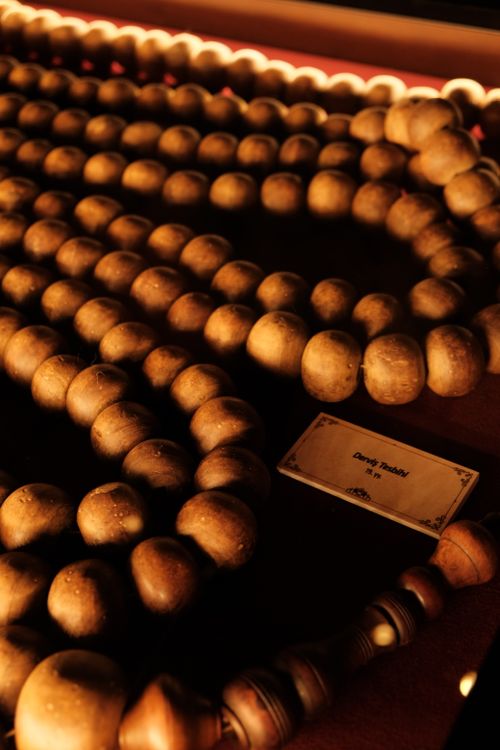 Free Close-up photo of historic wooden beads displayed in a dimly lit museum exhibit. Stock Photo