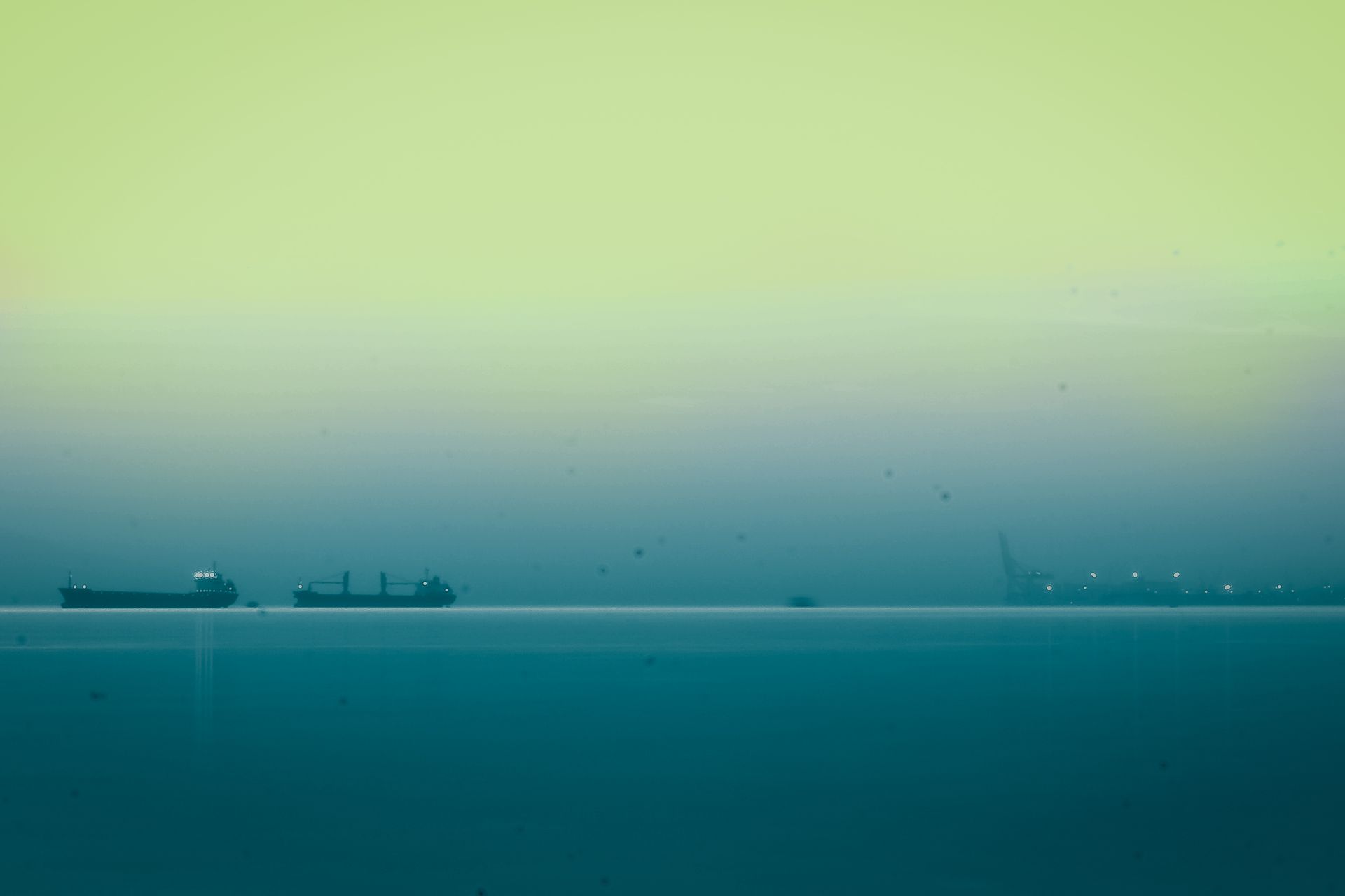 Idyllic dawn view of cargo ships on a foggy sea near İzmit, Türkiye, capturing serene tranquility.