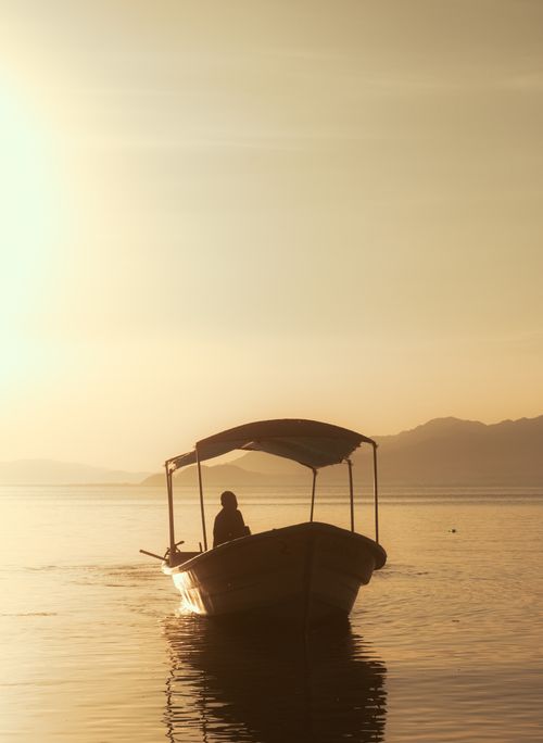 Free Silhouette of a person in a boat on Lake Chapala during sunset in Jocotepec, Mexico. Stock Photo