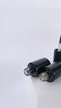Close-up of open nail polish bottles on a white background with ample copyspace.