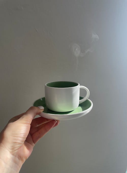 Hand Holding a Hot Cup of Tea 