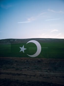 View of Turkish landscape through a train window with crescent and star reflection.