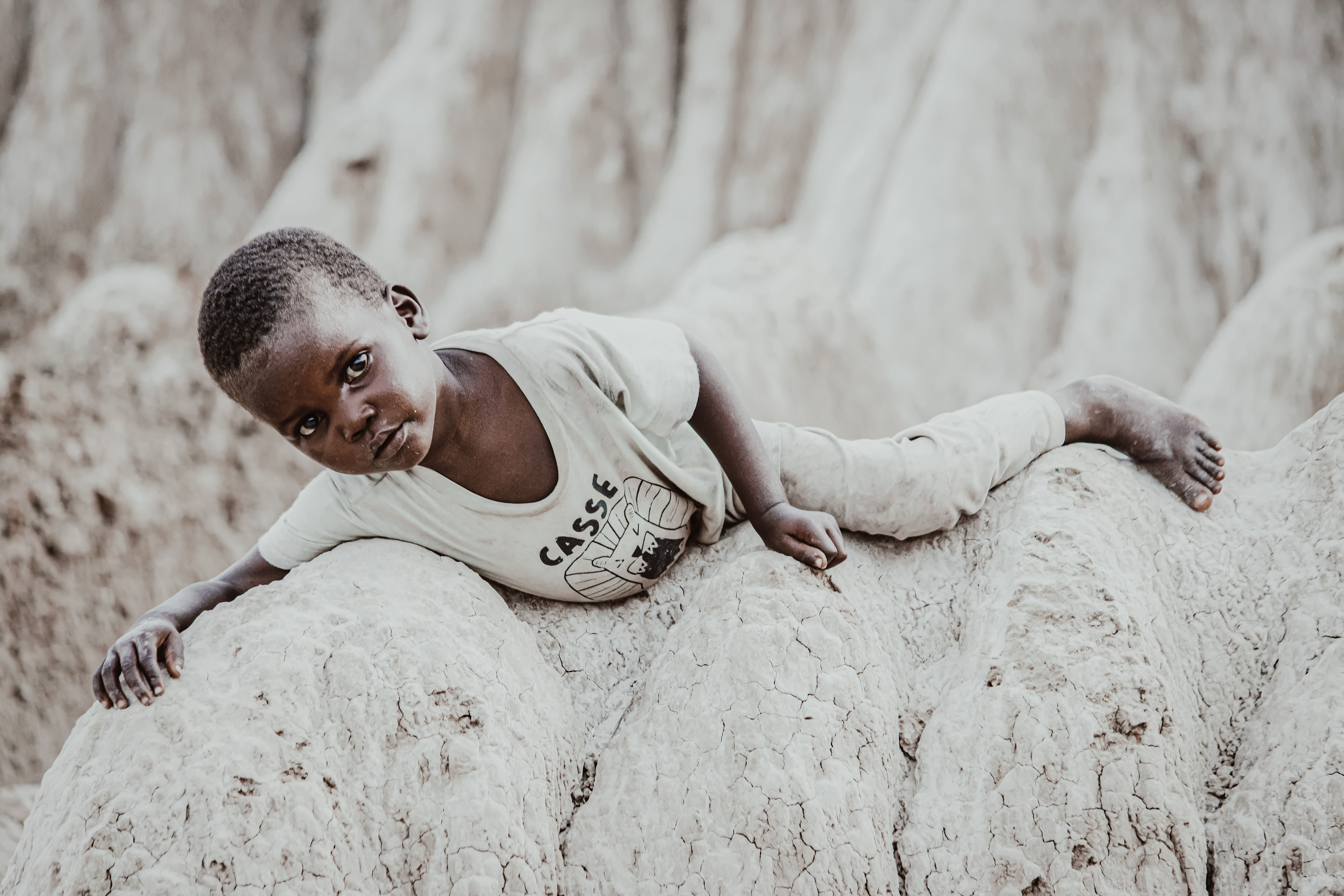 African boy lying on stones, Angola