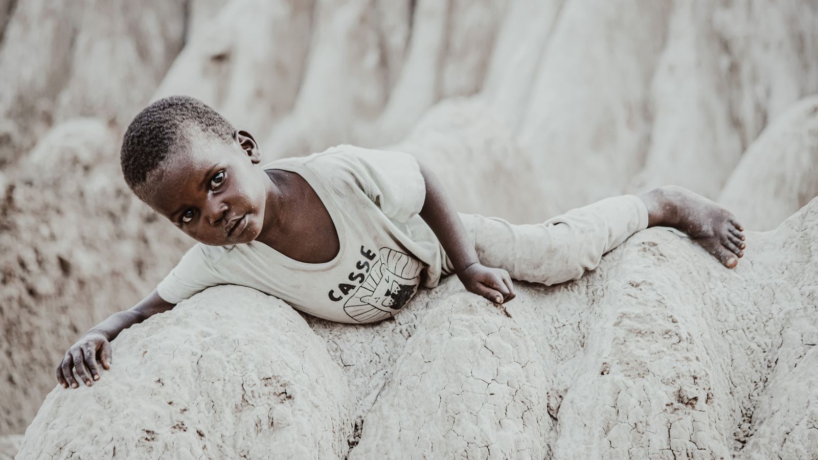 African boy lying on stones, Angola