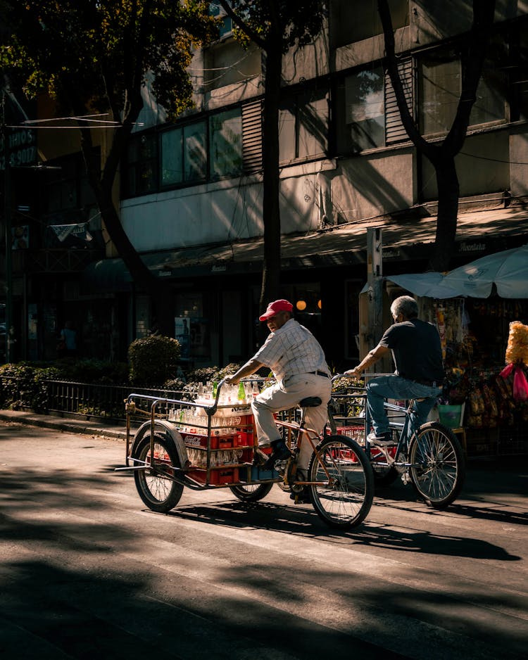 Man Riding Bicycle With Cart