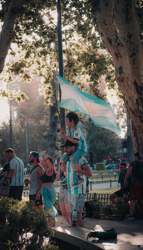 People with Argentinian Flag and Wearing Football T-shirts Celebrating in City 