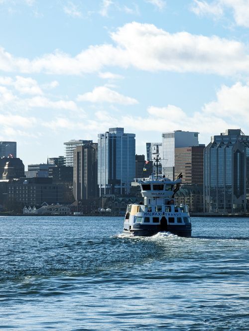 Free A bustling ferry navigates the Halifax harbor with the city skyline as a backdrop on a bright, sunny day. Stock Photo