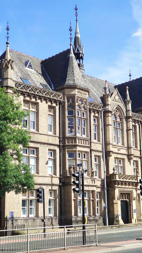 Free Gothic Revival building facade with intricate details under a clear blue sky. Stock Photo