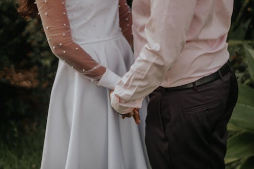 Close-up of Bride and Groom Holding Hands 