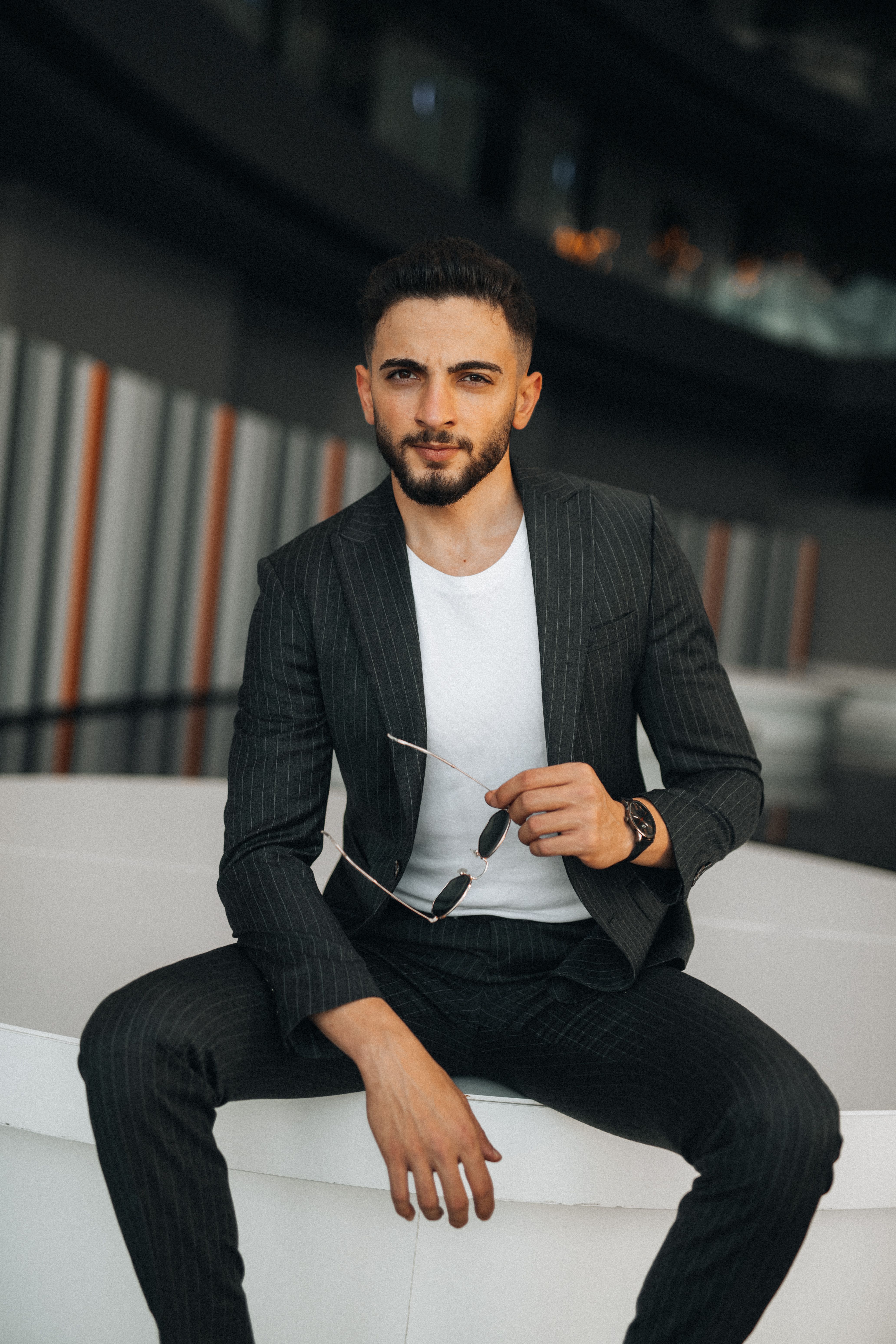 Young Man in a Suit Sitting in a Modern Room  Free Stock Photo