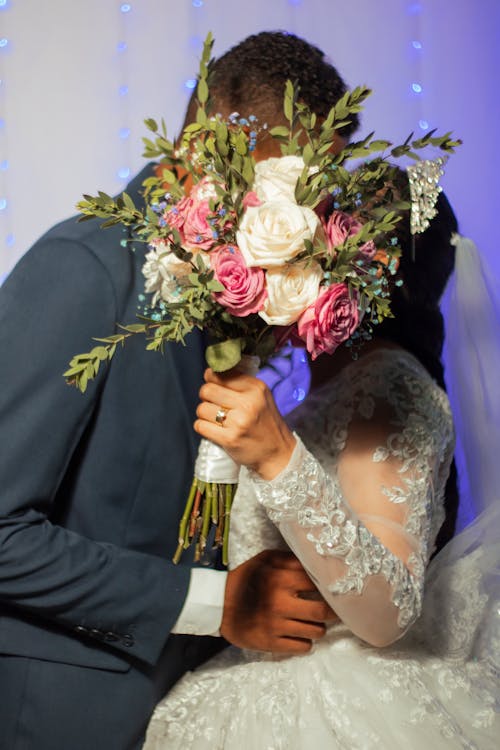 Bride and Groom Kissing behind a Bouquet 