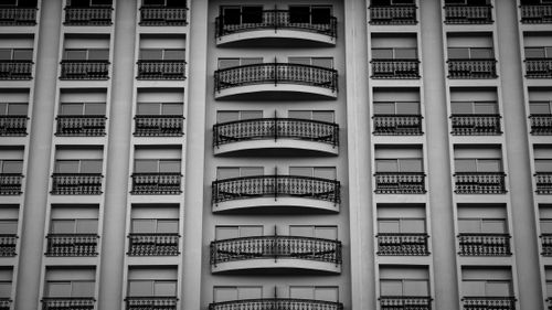 Free Black and white photo of a symmetrical modern apartment building facade with balconies. Stock Photo