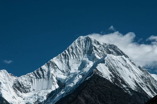 Free A breathtaking view of a snow-covered mountain peak against a clear blue sky, showcasing rugged beauty. Stock Photo