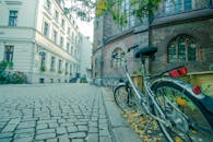 一辆自行车靠在柏林鹅卵石街道旁的一座历史建筑上