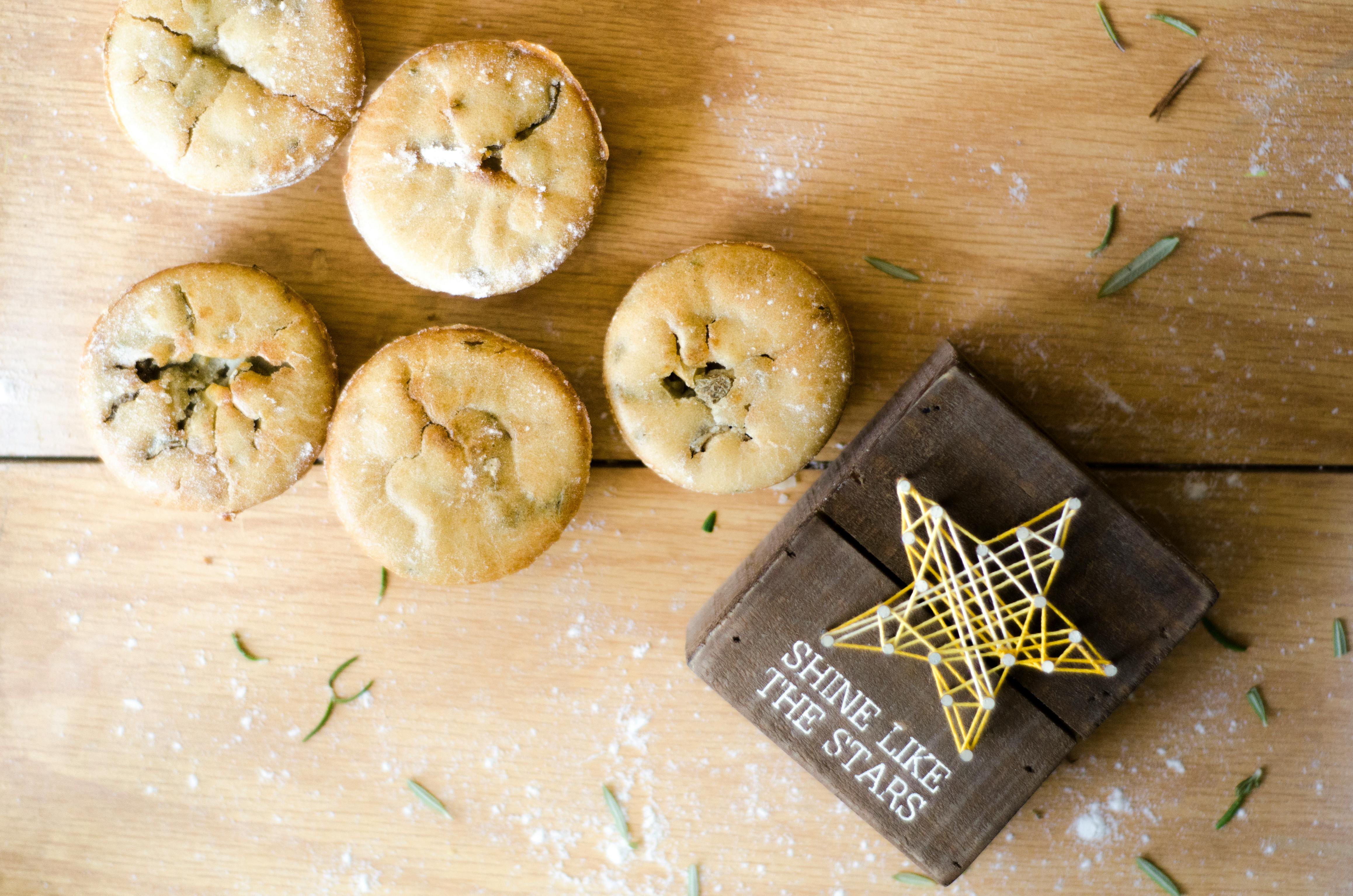 A set of homemade mini pies on a wooden surface with a star decoration and inspirational text.