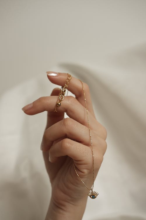 Free Woman Holding a Golden Necklace  Stock Photo