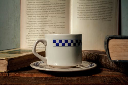 A cup of coffee sits on top of an open book