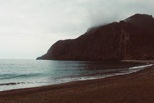 在摩洛哥巴德斯，多云的天空下，宁静的海滩与山峦相映成趣