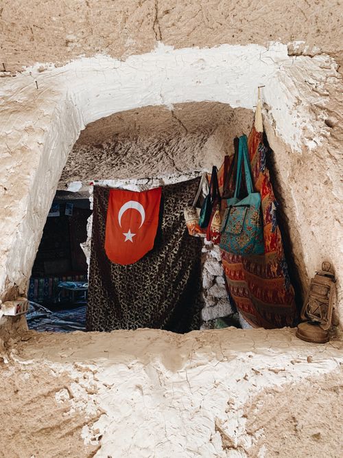 Free View of colorful bags and a Turkish flag in a cave dwelling in Cappadocia, Turkey. Stock Photo