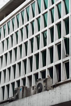 Geometric facade of an urban building with air conditioners in Hanoi, Vietnam.