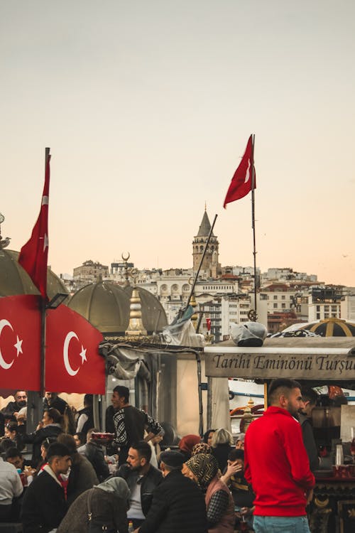 Galata Tower over People and Flags of Turkey