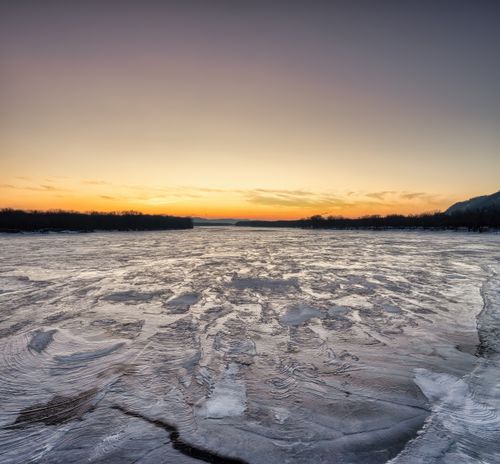 Free A stunning sunrise over an ice-covered lake in Minneiska, Minnesota, showcasing winter beauty. Stock Photo