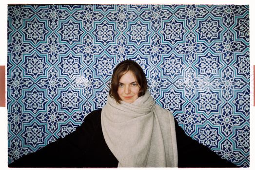 Woman Standing in front of Mosaic Wall
