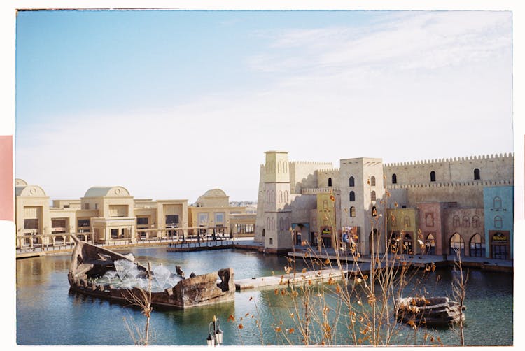 Ship Shaped Fountain And City Buildings