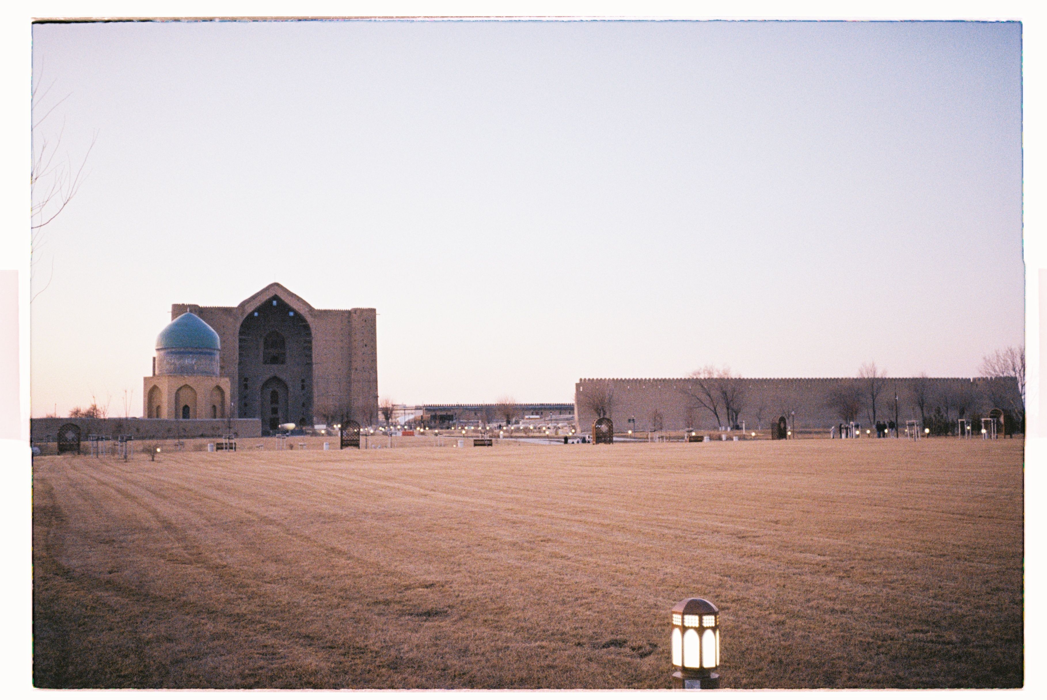 Mausoleum with a blue dome in Turkestan, showcasing traditional architecture at twilight.