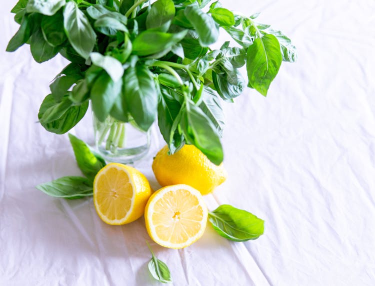 Sliced Lemon And Basil Leaves On Glass