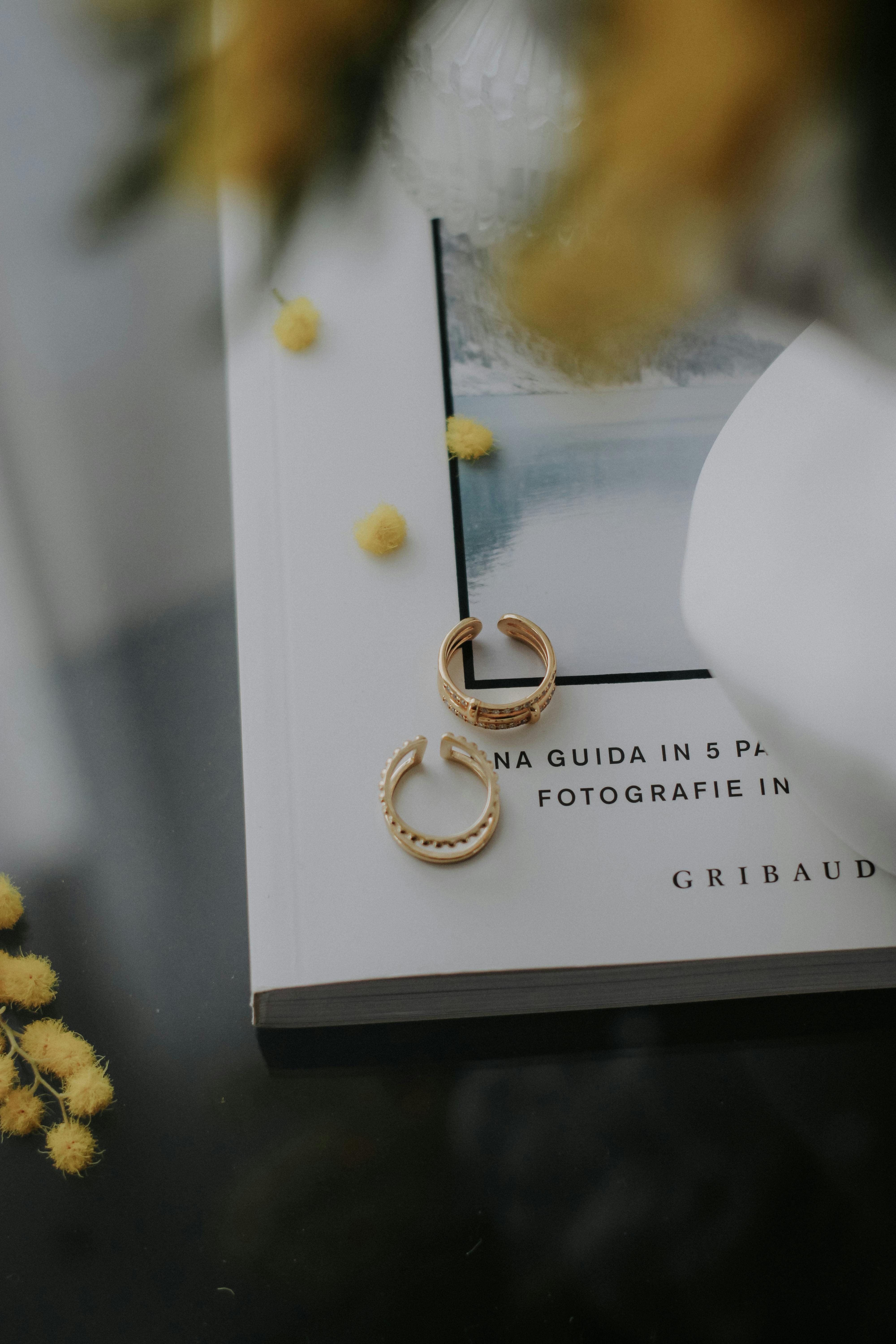 gold earrings on top of a book