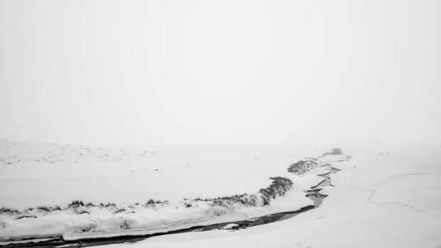 Serene winter scene featuring a snow-covered landscape and a winding frozen river.