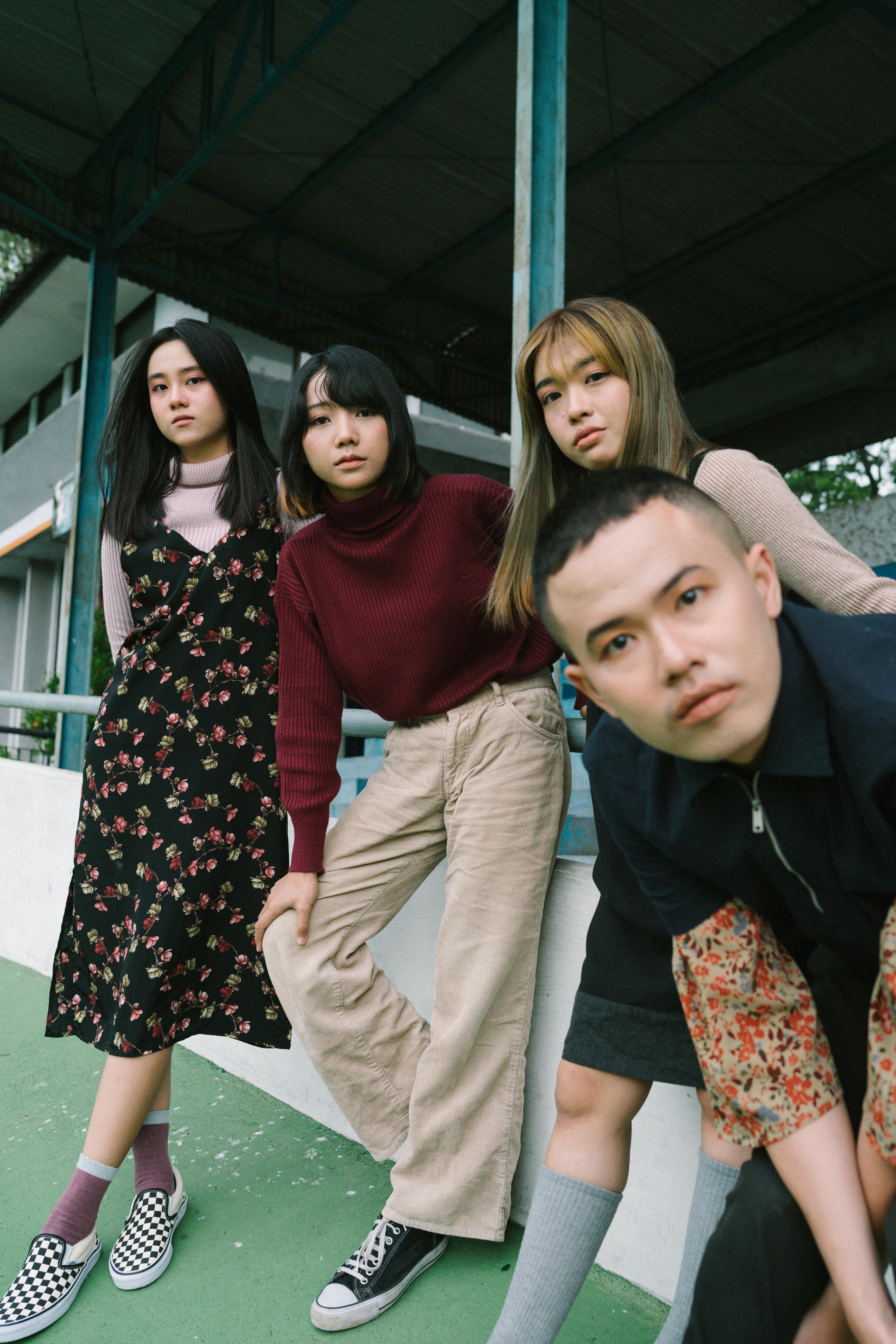 A group of young adults striking a pose in an outdoor setting.
