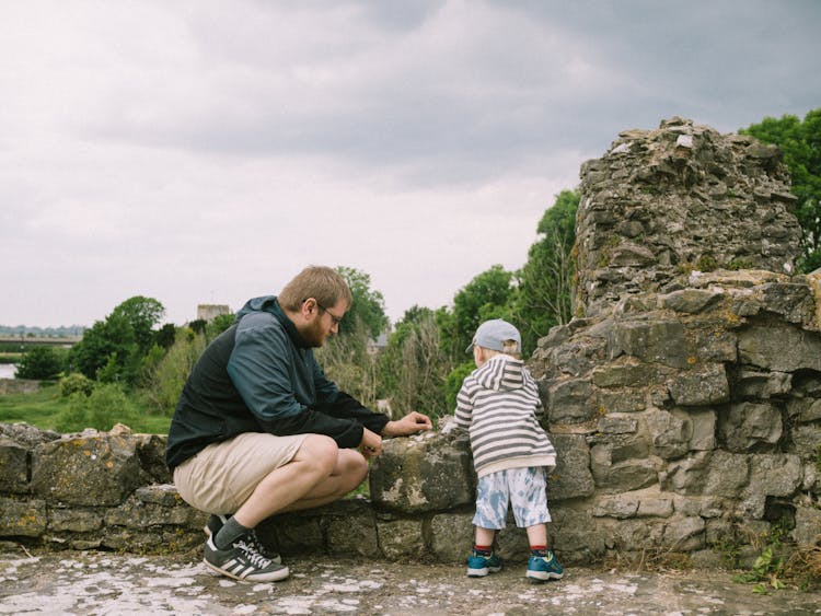 Man Playing With Child With Stones Outdoors