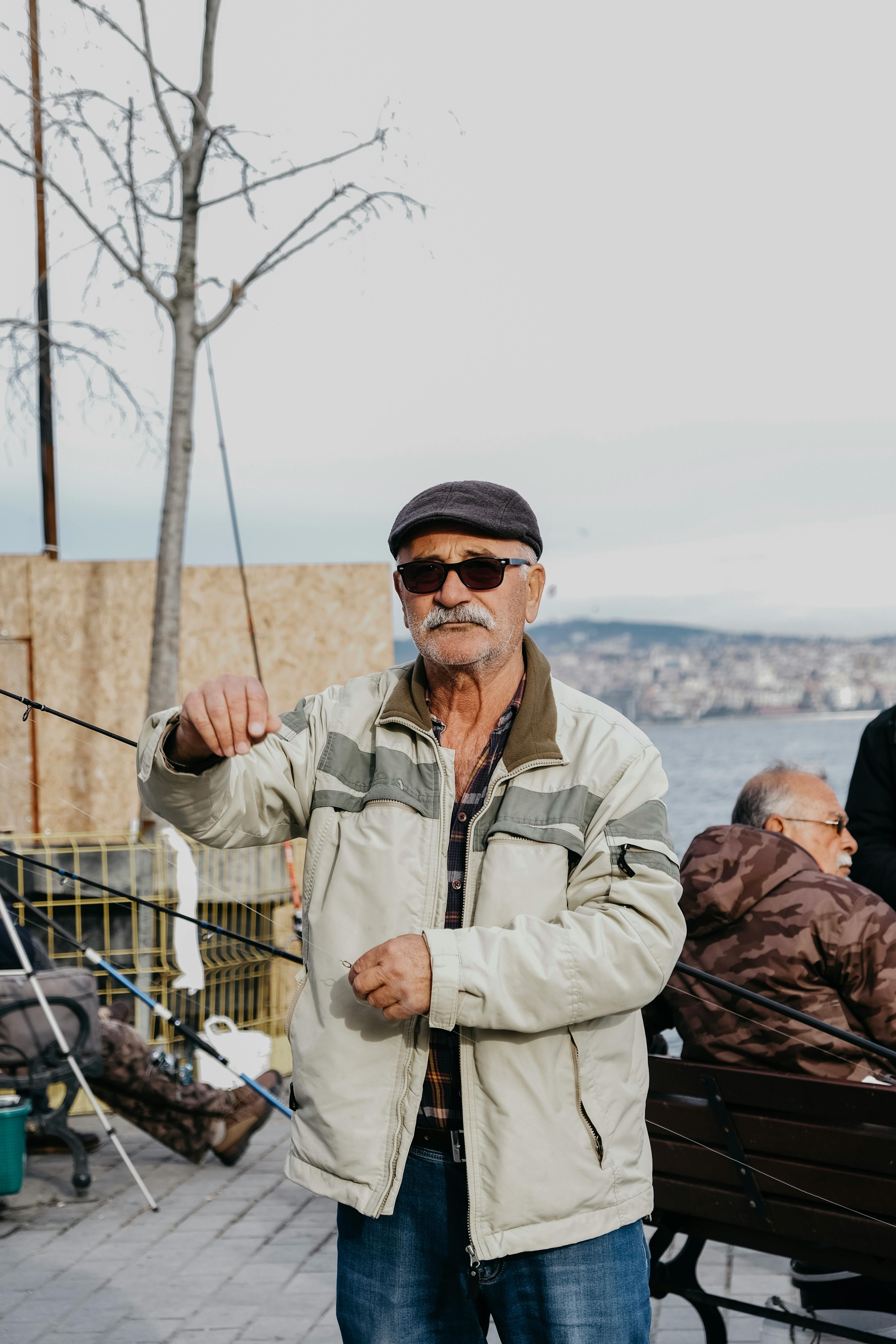 Senior Man Standing at a Waterfront with a Fishing Rod · Free