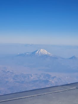 A breathtaking view of snow-capped mountains from an airplane window.